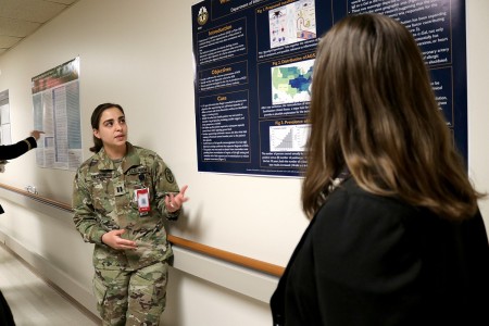 Capt. Ariana Enzerink, a resident in Internal Medicine, shares her research with attendees of the poster judging session of the 2023 Col. Pat C. Kelly Madigan Research Day on Friday, May 5, 2023, at Madigan Army Medical Center on Joint Base Lewis-McChord, Wash.